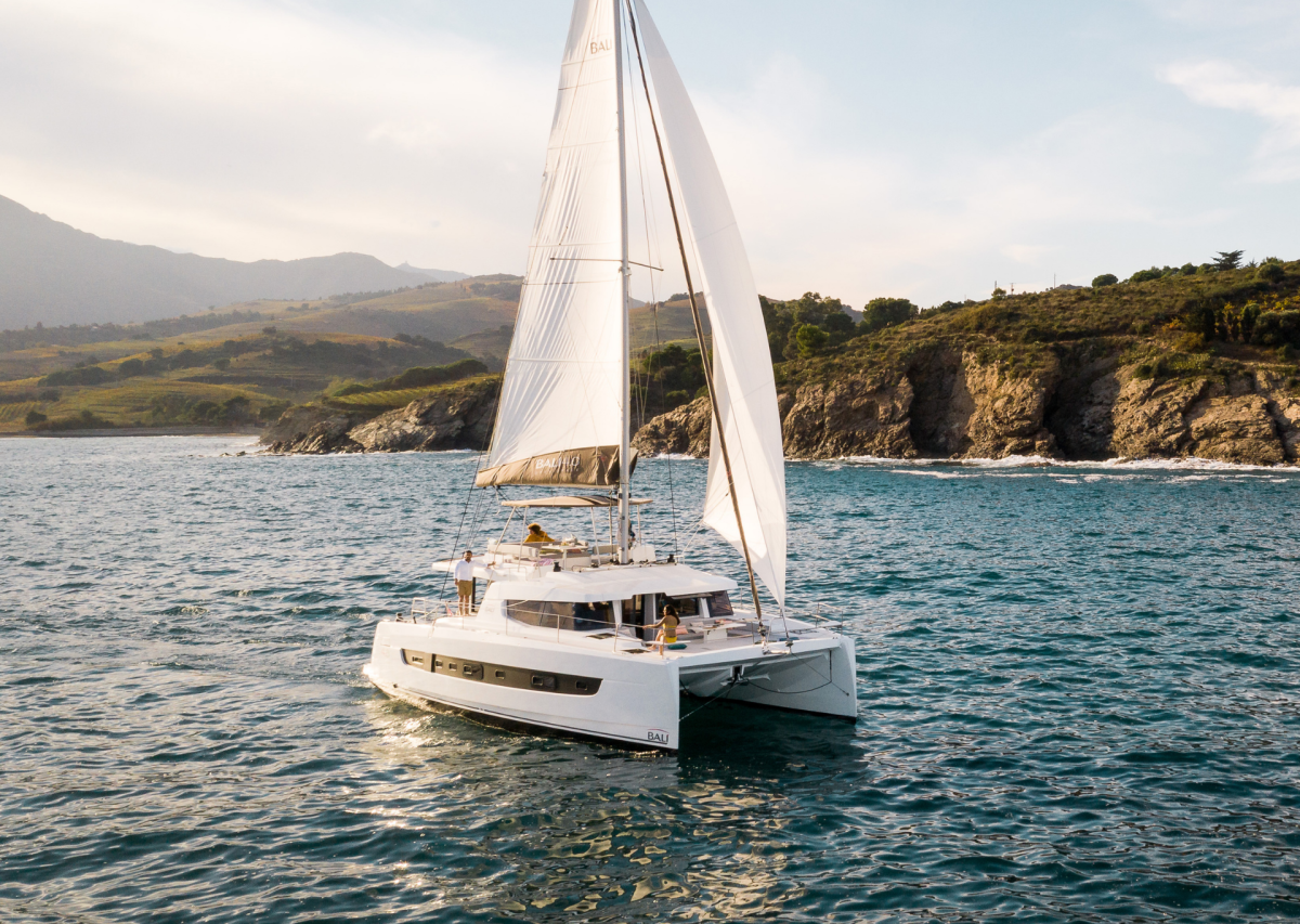 Bali 4.6 sailing with a woman at the helm and guests enjoying the foredeck