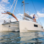 A woman diving from the deck of a Lagoon 38 catamaran at anchor