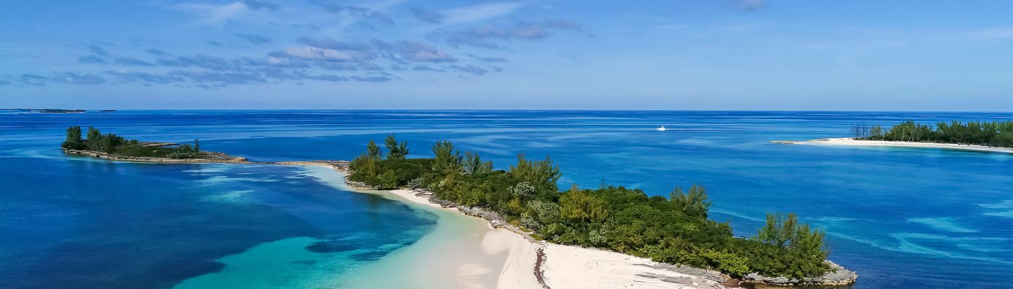 Aerial view of a stretch of white sand surrounded by turquoise water in the Bahamas