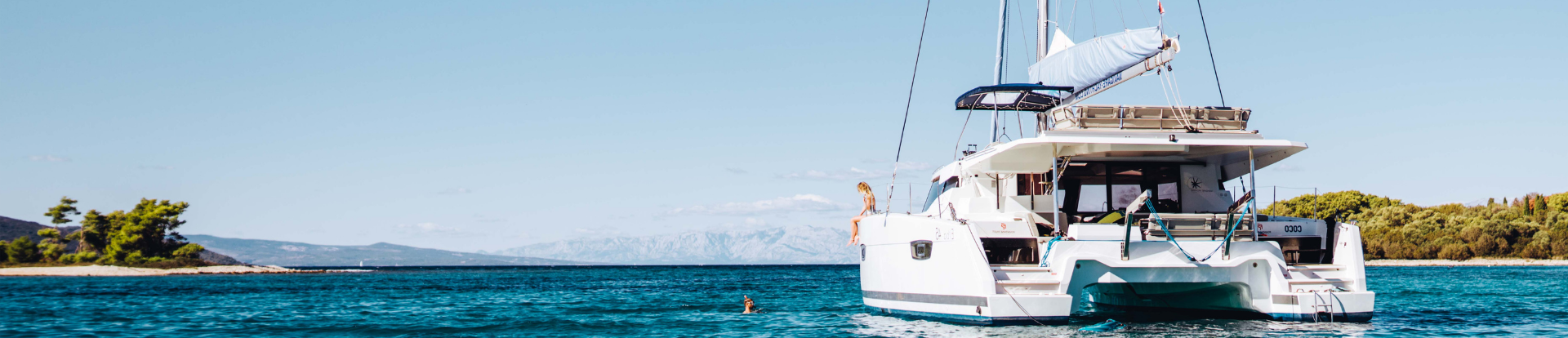 People swimming at anchor. Sailing catamaran at anchor
