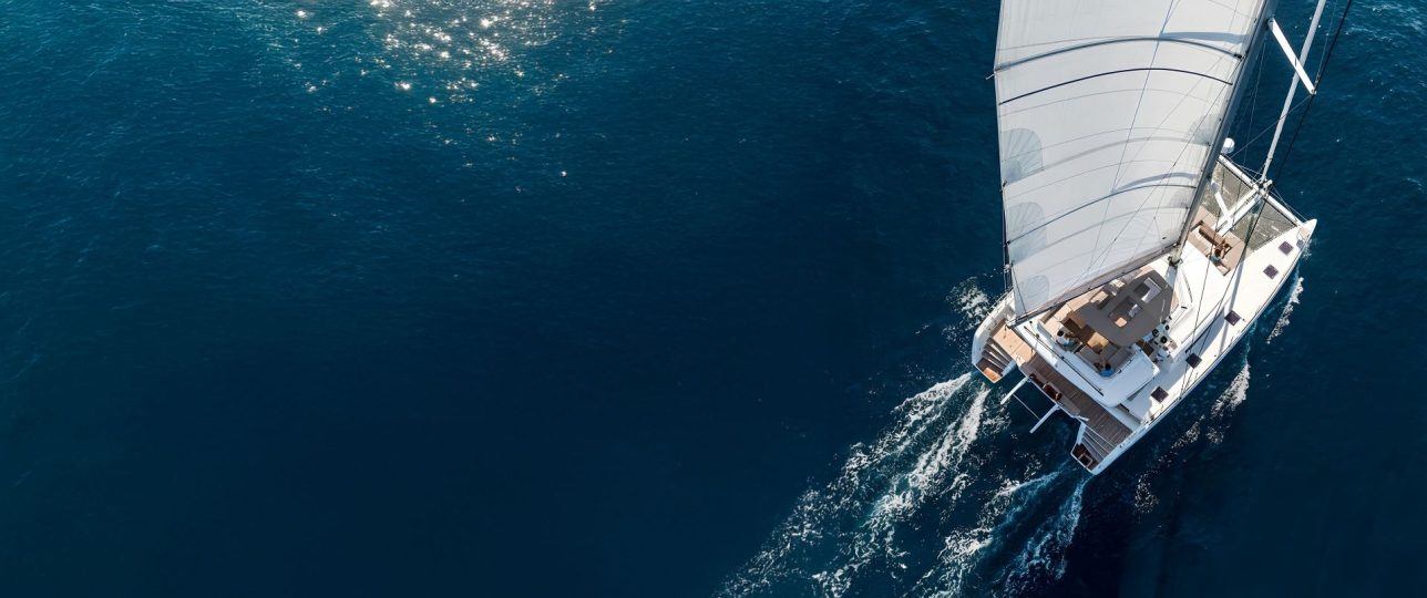Catamaran yacht drone view sailing on dark blue water