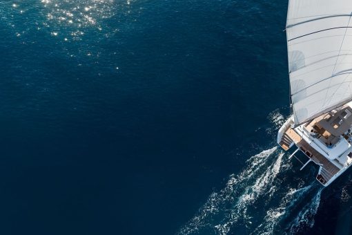 Catamaran yacht drone view sailing on dark blue water